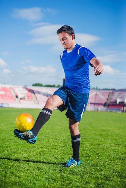 Foto gratuita jugador de fútbol equilibrando pelota en pie