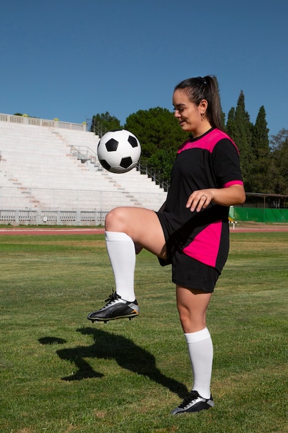 Foto gratuita jugador de fútbol femenino de tiro completo en el campo