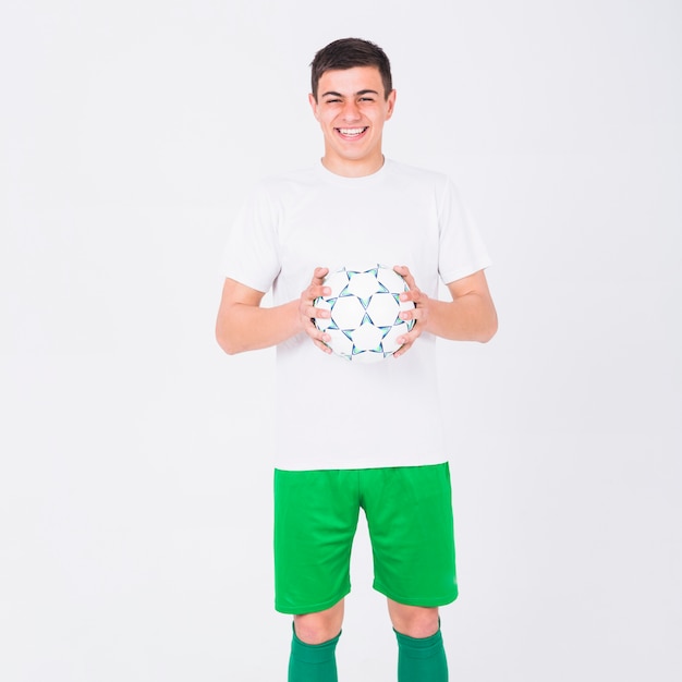 Foto gratuita jugador de fútbol sonriente sujetando pelota