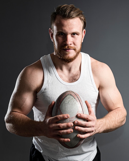 Foto gratuita jugador de rugby masculino guapo sosteniendo la bola