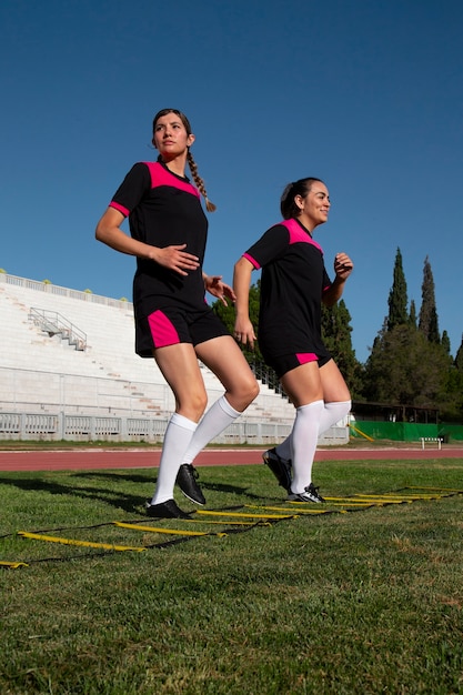Foto gratuita jugadores de fútbol femenino de tiro completo en el campo