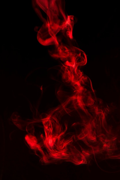 Foto gratuita olas de humo rojo brillante sobre fondo negro