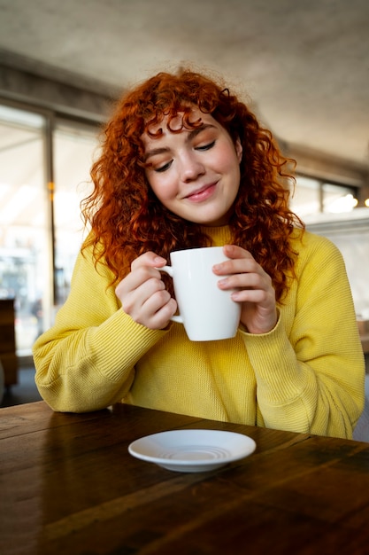 Foto gratuita mujer bebiendo chocolate caliente en el cafe
