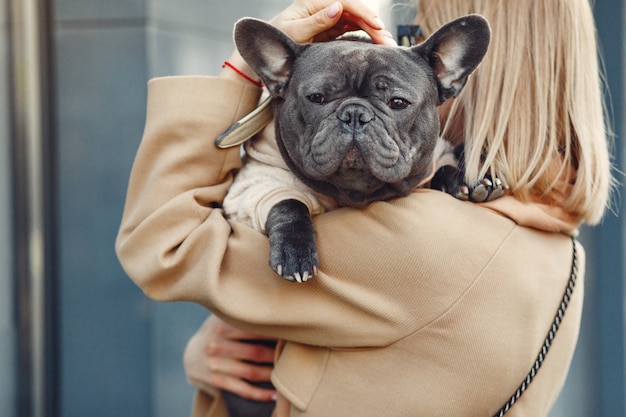 Foto gratuita mujer elegante con un abrigo marrón con bulldog negro