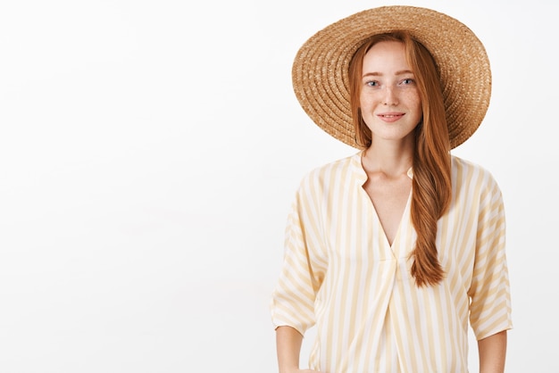 Foto gratuita mujer feliz con pelo rojo y pecas en el moderno sombrero de paja y blusa amarilla sonriendo tierna y femenina tomando fotos de la vieja europa