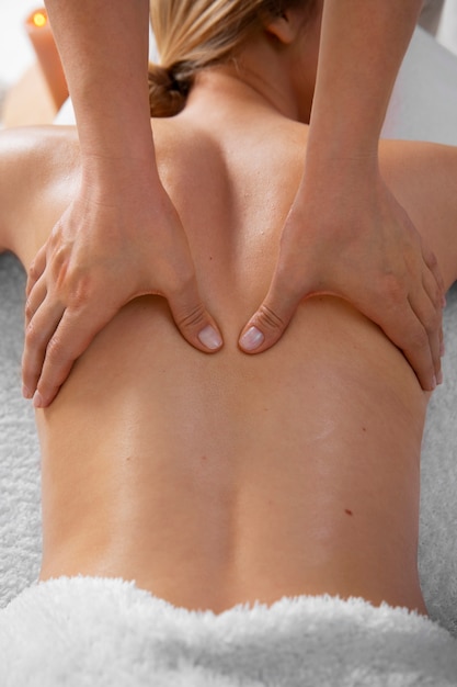 Foto gratuita mujer recibiendo un masaje de espalda de masajista