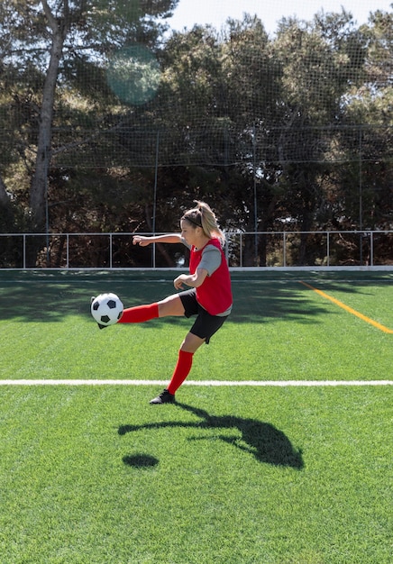 Foto gratuita mujer de tiro completo jugando al fútbol