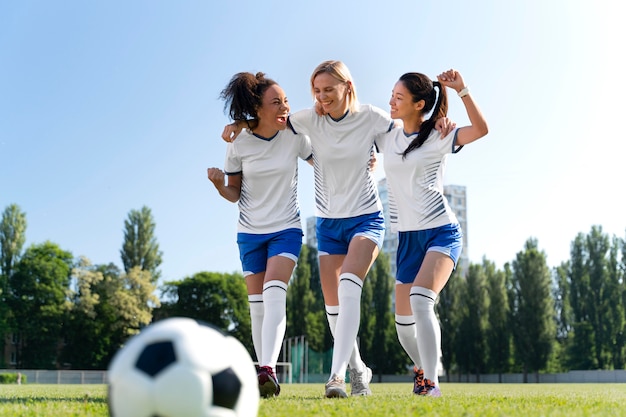 Foto gratuita mujeres jóvenes jugando en un equipo de fútbol