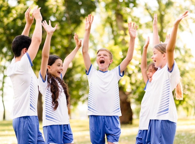 Foto gratuita niños entusiastas preparándose para jugar al fútbol