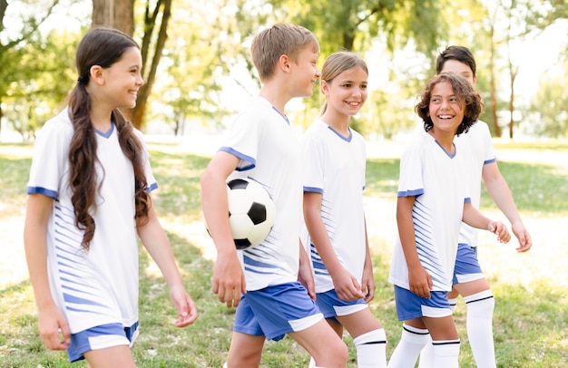 Foto gratuita niños en equipamiento de fútbol preparándose para un partido.