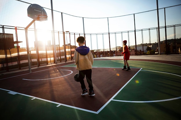 Foto gratuita niños jugando baloncesto en un campo
