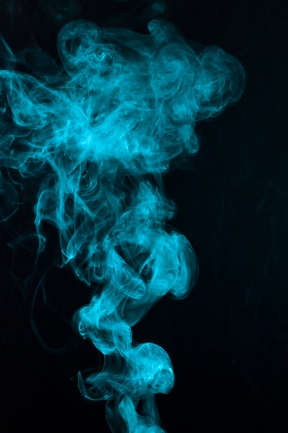 Patrón de humo azul hermoso extendido sobre fondo negro