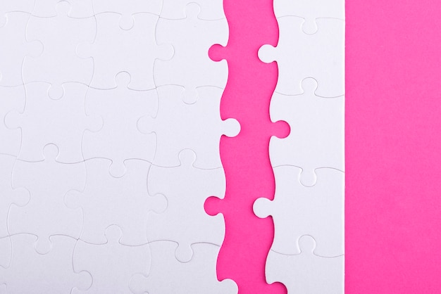 Foto gratuita piezas de rompecabezas blancas planas y fondo rosa