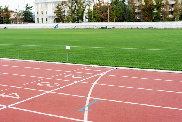 Foto gratuita pista de atletismo con campo de hierba en día soleado