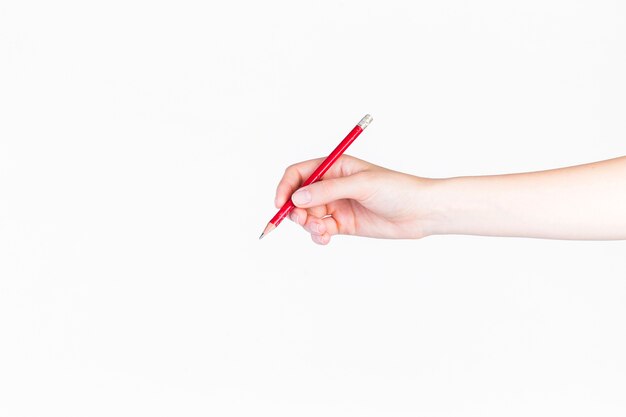 Primer plano de una persona que sostiene el lápiz en el fondo blanco