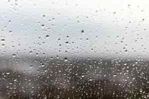 Foto gratuita primer plano de una ventana en un día lluvioso, gotas de lluvia rodando por la ventana