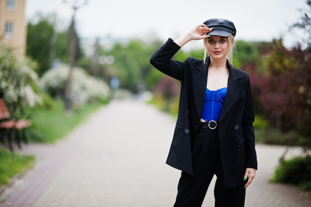 Foto gratuita retrato de una hermosa modelo rubia de moda sexy con gorra y corsé azul negro con maquillaje brillante