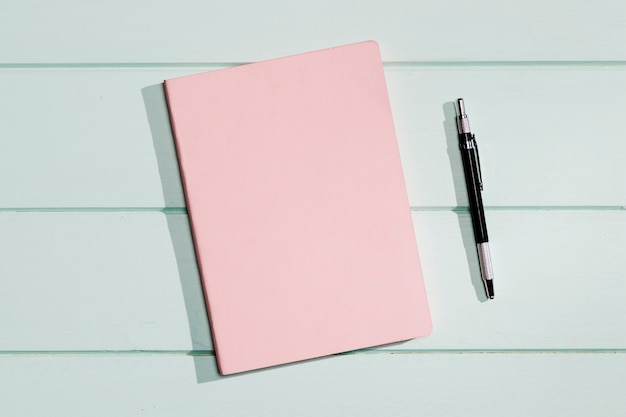 Foto gratuita tapa rosa de un bloc de notas con bolígrafo