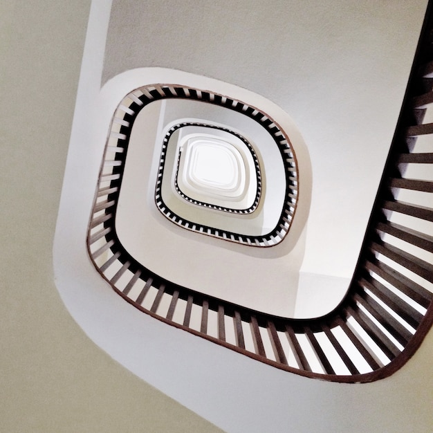 Foto gratuita tiro de ángulo bajo de una moderna escalera de caracol en blanco