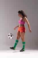 Foto gratuita tiro completo fit mujer jugando con balón de fútbol
