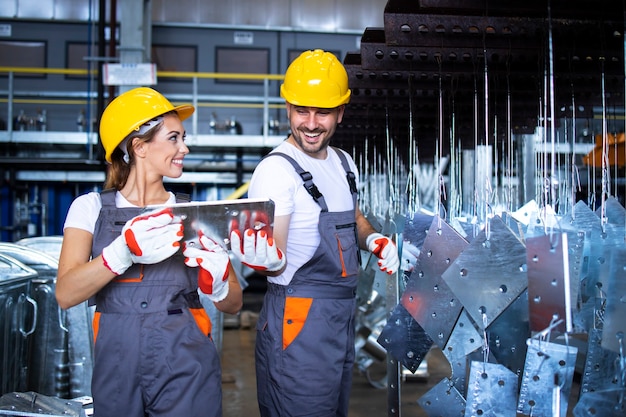 Foto gratuita trabajadores de la fábrica que trabajan juntos en la línea de producción de metales industriales