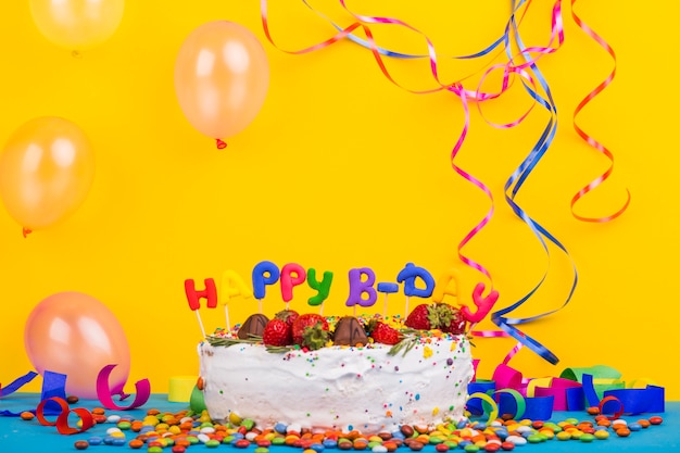 Foto gratuita vista frontal tarta cumpleaños rodeada de elementos de fiesta