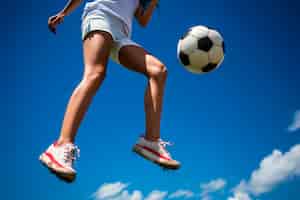Foto gratuita vista del jugador de fútbol saltando en el aire con la pelota