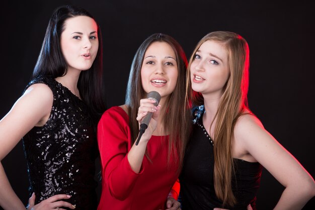 Tre giovani donne attraenti che cantano