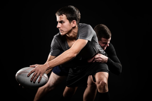 Vista frontale dei giocatori di rugby maschile con la palla