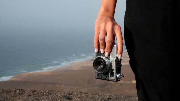 Giovane donna che usa una macchina fotografica in vacanza
