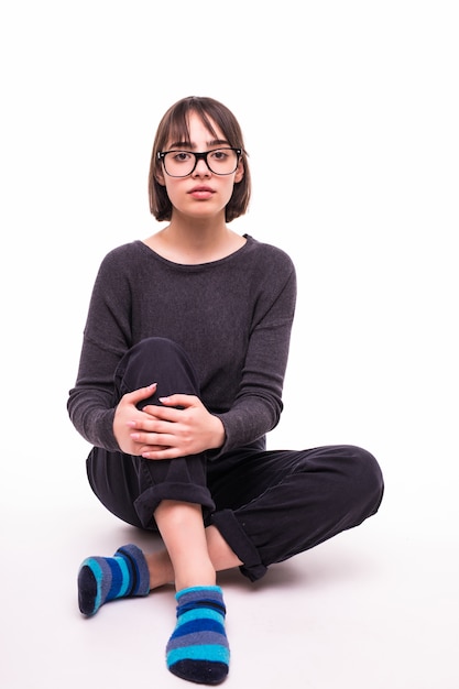 Free photo teenage girl in glasses sitting on the floor isolated
