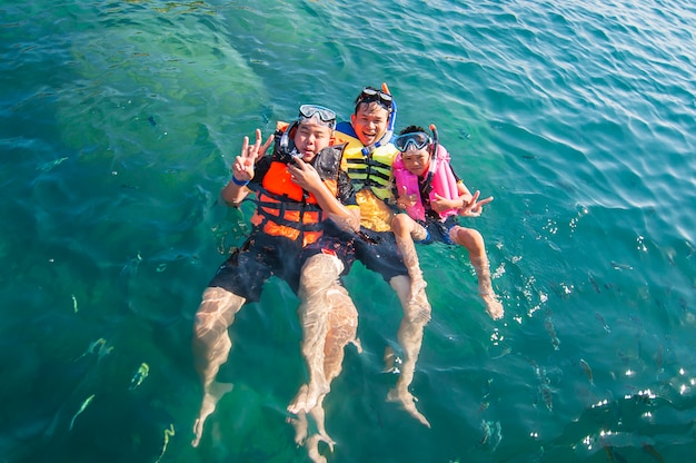 Free photo three guys floating happily in the sea water