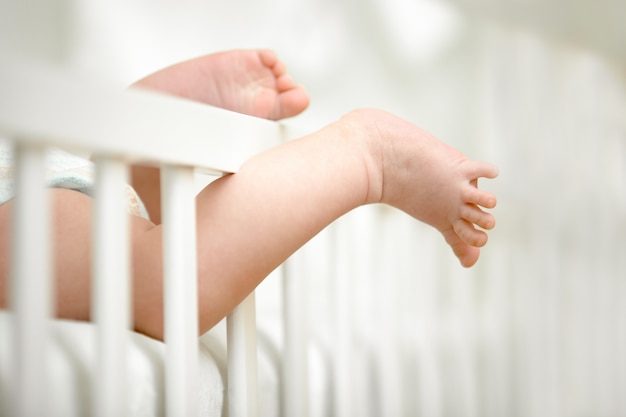 무료 사진 유아용 침대 프레임 사이에 잡힌 작은 다리
