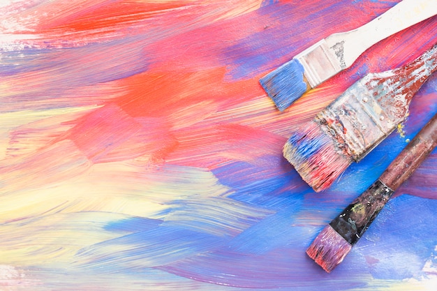 Free photo top view of colorful brushstroke and dirty paint brushes