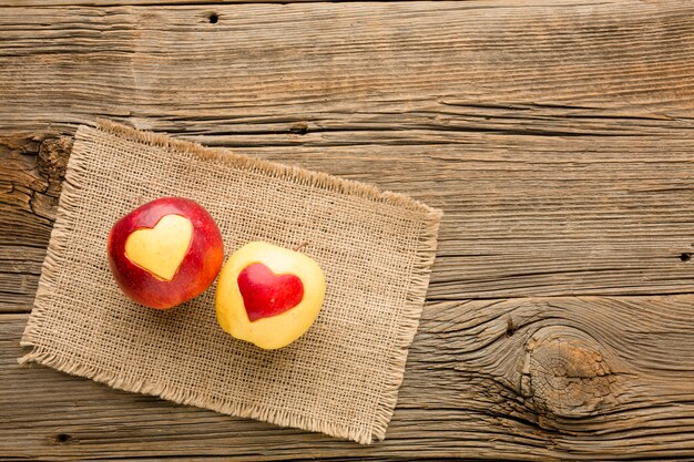 Top view of cloth and apple with fruit heart shapes and copy space