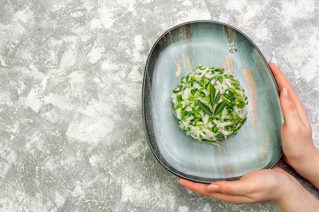 Вид сверху вкусный салат состоит из зелени и капусты внутри тарелки