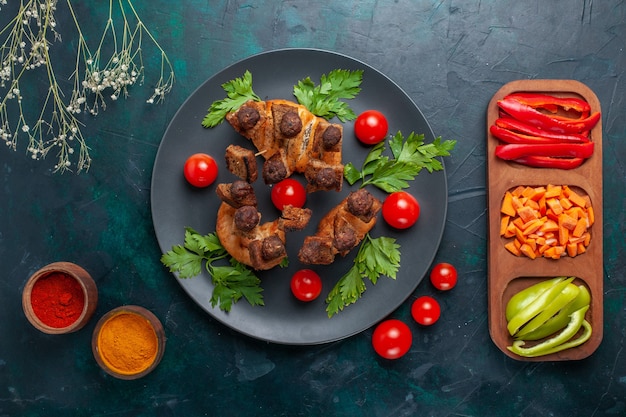 Бесплатное фото Вид сверху жареные кусочки мяса с овощами и приправами на темно-синей поверхности овощная еда еда мясной ужин здоровье