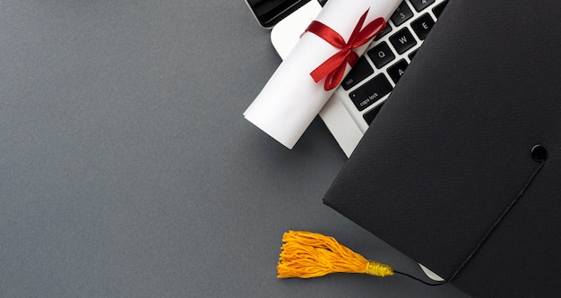Бесплатное фото Вид сверху ноутбука с дипломом и академической шапкой