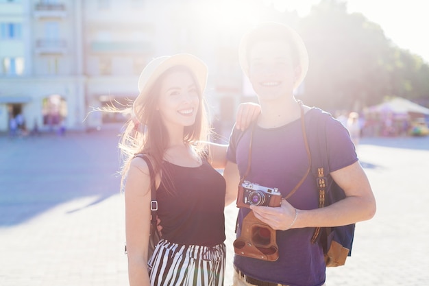 Free photo tourist couple sightseeing in city with sun effect