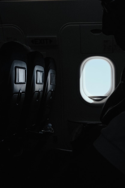 Free photo vertical shot of the window inside an airplane at the time of the flight