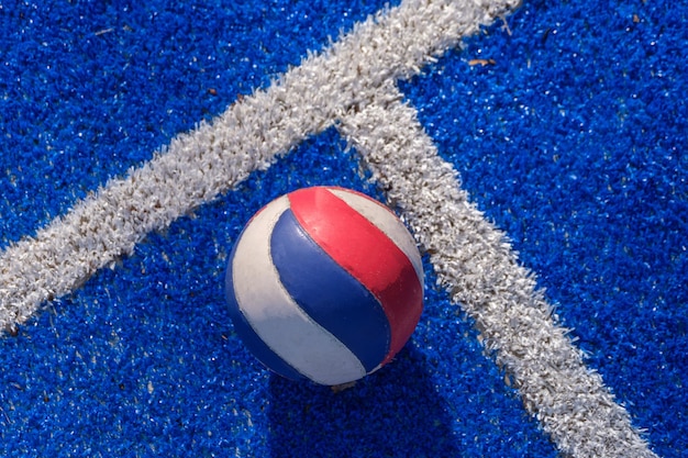 Foto gratuita una palla di voloy che si posa sul campo sportivo blu pronto per essere raccolto