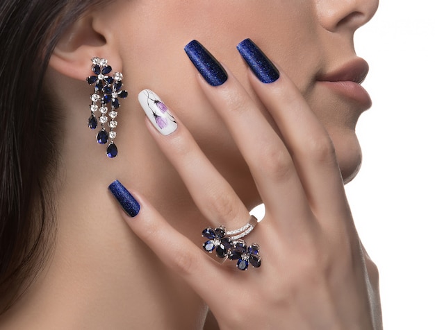 Free photo woman with nail art promoting design luxury earrings and ring.
