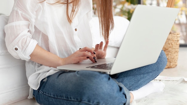 Бесплатное фото Женщина, работающая со своим ноутбуком на коленях