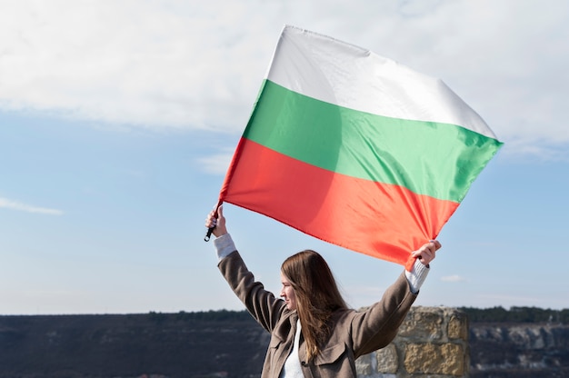 Бесплатное фото Женщина держит болгарский флаг на улице