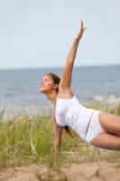 Бесплатное фото Женщина делает йогу на пляже