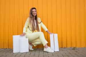 Free photo woman sitting next to white shopping bags