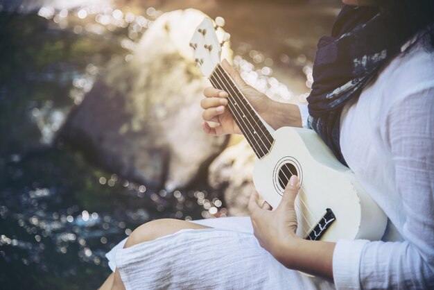 Женщины играют в гавайскую гитару впервые на водопаде