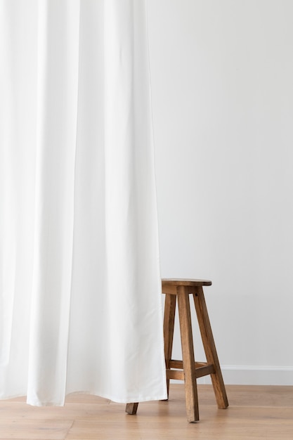 Free photo wooden stool behind a white curtain