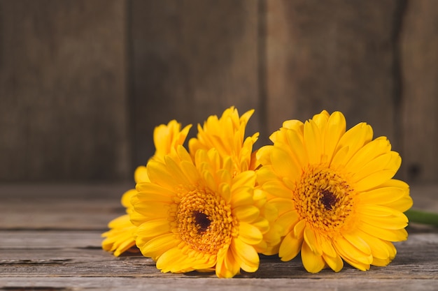 Бесплатное фото Желтые цветы на деревянный стол