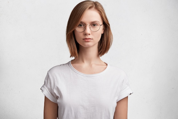 Young woman with round glasses and white T-shirt